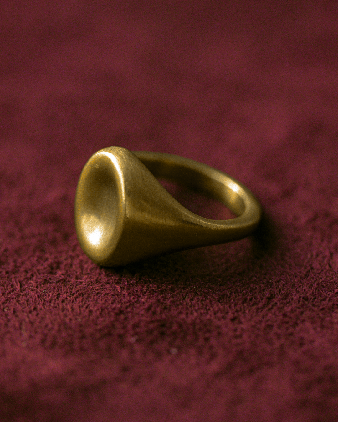 Mushu ring in 14k gold by dear_ jewelry photographed on textured burgundy fabric.